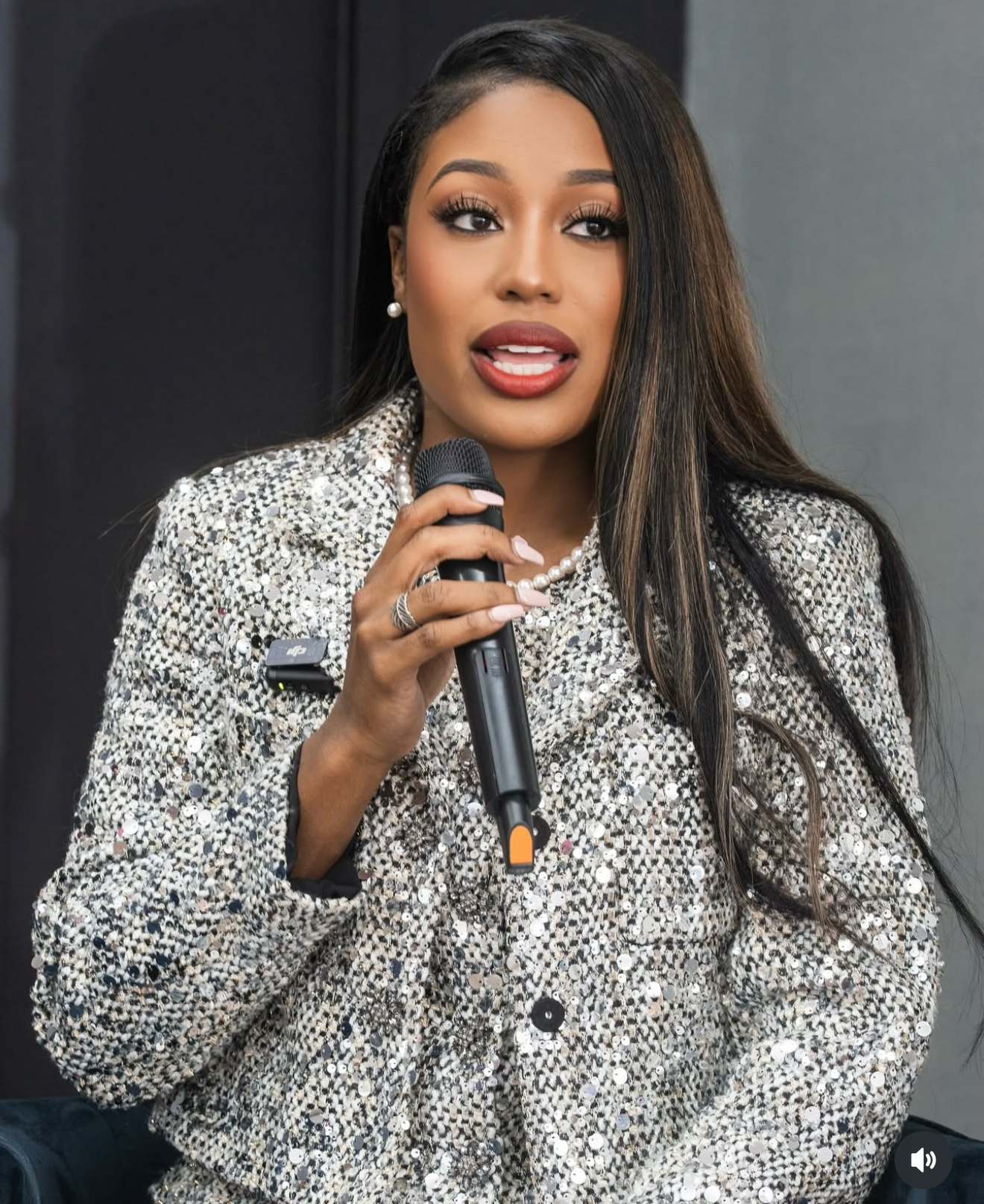 Ashley speaking into a microphone at an event